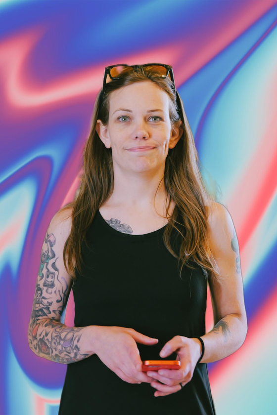 Jess Thackston standing in front of a colorful swirled backdrop